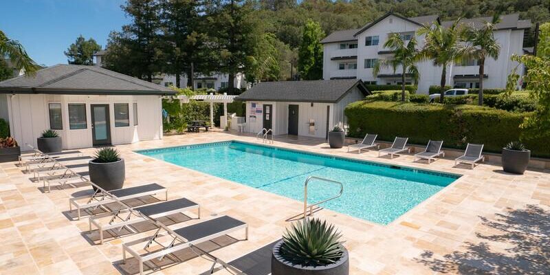 outdoor setting with pool, chairs, and building in back